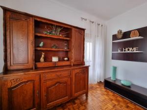duża drewniana szafka w salonie w obiekcie Modern & Cosy Apartment in Fundão Centre w mieście Fundão