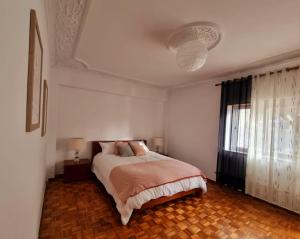 a white bedroom with a bed and a window at Modern & Cosy Apartment in Fundão Centre in Fundão