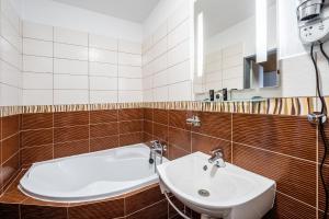 a bathroom with a sink and a mirror at Penzion a Restaurant Barbora in Kutná Hora