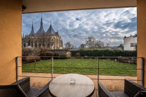 a table on a balcony with a view of a building at Penzion a Restaurant Barbora in Kutná Hora
