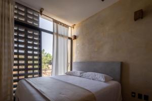 ein Schlafzimmer mit einem Bett und einem großen Fenster in der Unterkunft Casa Kame in Puerto Escondido