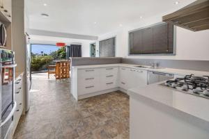 a kitchen with white cabinets and a counter top at Spa, Stay & Holiday in Rotorua