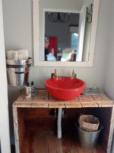 a bathroom with a red sink and a mirror at Rocks & Roses Farm stay in Lochiel