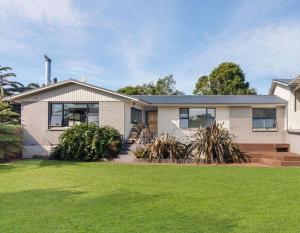 a house with a green lawn in front of it at Spa, Stay & Holiday in Rotorua
