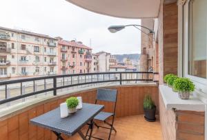 uma mesa e cadeiras numa varanda com vista em Casco Viejo junto a BilboRock em Bilbao