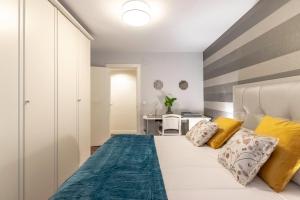 um quarto com uma cama branca e almofadas amarelas em Casco Viejo junto a BilboRock em Bilbau