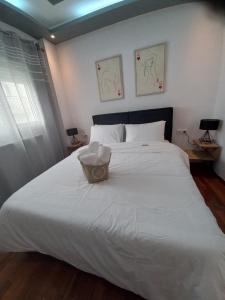 a white bed with a basket on top of it at A&D Central Apartment in Volos