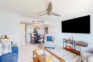 a living room with a blue couch and a flat screen tv at Tybee Stars in Tybee Island