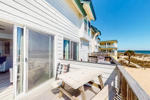 a porch with a wooden bench on the beach at Tybee Stars in Tybee Island