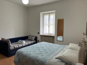 ein Schlafzimmer mit einem Bett und einem Sofa in der Unterkunft camere Rosignoli in Assisi