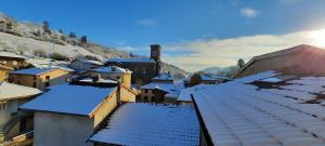 a city with snow covered roofs and buildings at Logis Hôtel Le Saint Clément in Saint-Clement-sur-Valsonne