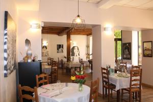 a dining room with white tables and chairs at Hôtel Restaurant Le Saint Clément in Saint-Clement-sur-Valsonne