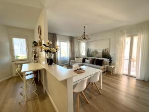 a kitchen and living room with a table and chairs at Family Apartment 2 Sirmione in Sirmione