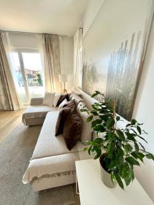 uma sala de estar com um sofá e um vaso de plantas em Family Apartment 2 Sirmione em Sirmione