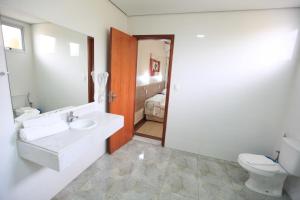a bathroom with a sink and a toilet at Hotel Oly Plaza in Piracicaba