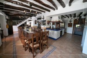 een keuken met een tafel en stoelen in een kamer bij Cortijo El Segador y El Capricho in Almedinilla