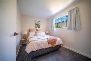 a bedroom with a bed and a window at City Apartments in Nelson