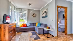 un soggiorno con divano e TV di Apartament H7 - 5D Apartamenty a Świeradów-Zdrój