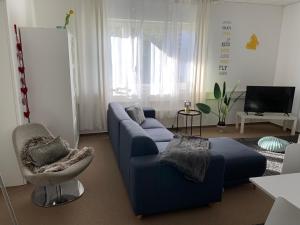 a living room with a blue couch and a chair at Apartment Leipzig Zentrum mit Tiefgarage in Leipzig