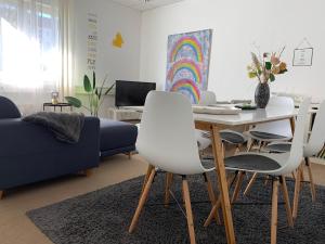 a living room with a table and white chairs at Apartment Leipzig Zentrum mit Tiefgarage in Leipzig