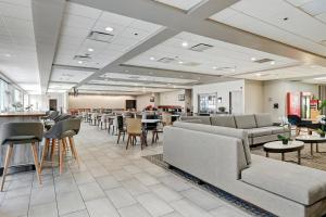 a waiting room with couches and tables and chairs at Holiday Inn - Piscataway - Somerset, an IHG Hotel in Piscataway