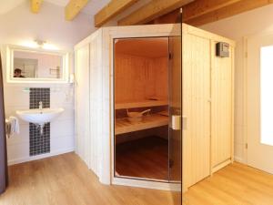 a glass shower in a bathroom with a sink at Apartment in Lissendorf with a paid private sauna in Lissendorf