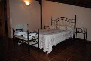 1 dormitorio con 1 cama y 1 silla en una habitación en Hosteria El Corralucu en Serdio