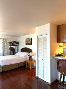 a bedroom with a bed and a table with a lamp at Haukea at Kona Joe Coffee Farm in Kealakekua