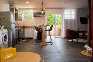 a kitchen with a table and chairs in a room at LA RESIDENCE DU ROCHER in Bourda