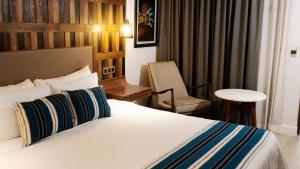 a hotel room with a bed and a chair at Hotel Indigo Guadalajara Expo, an IHG Hotel in Guadalajara