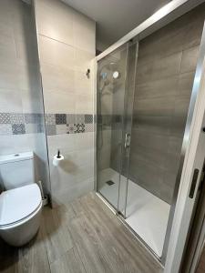 een badkamer met een toilet en een glazen douche bij IV Apartamento junto a PLAZA MAYOR in Salamanca