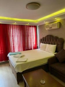 een slaapkamer met een groot bed en een bank bij RİXOS PERA Apartment in Istanbul