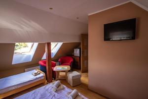 a room with two beds and a flat screen tv at U Rybaka in Braniewo