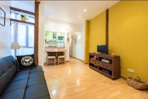 een woonkamer met een bank en een tafel bij Luminoso Apartamento en Lavapiés-Tirso de Molina in Madrid