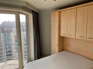 une chambre avec un lit et une grande fenêtre dans l'établissement Seasight View 1002, à Nieuport
