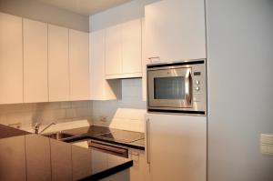 une cuisine avec des armoires blanches et un micro-ondes dans l'établissement Seasight View 1002, à Nieuport 4 autres photos
