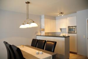 une cuisine et une salle à manger avec une table et des chaises dans l'établissement Seasight View 1002, à Nieuport