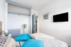 a bedroom with a bed and a tv on the wall at EDEN RENTALS Atogo Cozy Apartment in Granadilla de Abona