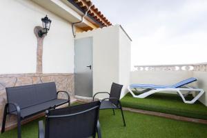 d'une terrasse avec des chaises, une table et un hamac. dans l'établissement EDEN RENTALS Atogo Cozy Apartment, à Granadilla de Abona