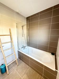 W łazience znajduje się wanna i prysznic. w obiekcie Maison d’architecte contemporaine – À 5 min des plages w mieście Ploemeur