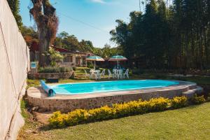 a swimming pool in a yard with a table and umbrellas at Koltincalli in Xico