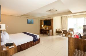 ein Hotelzimmer mit einem Bett und einem Wohnzimmer in der Unterkunft Casa Andina Select Pucallpa in Pucallpa