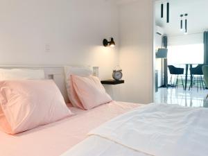 a bedroom with a white bed with pink pillows at SUNADOR - Adults Only in Crikvenica