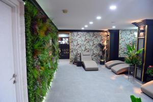 a room with a green wall with chairs and plants at Safir Hotels Silivri in Silivri
