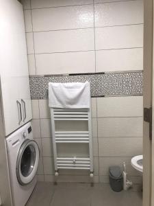 a bathroom with a toilet and a washing machine at zirve apart in Acıpayam