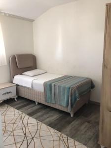 a small bedroom with a bed and a table at zirve apart in Acıpayam
