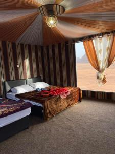 a bedroom with two beds and a window with a curtain at Tareqzwy wadi rum in Wadi Rum