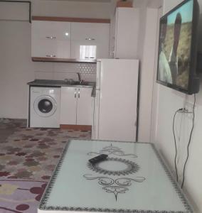a kitchen with a refrigerator and a table in a room at zirve apart in Acıpayam