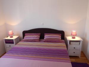 ein Schlafzimmer mit einem Bett mit zwei Nachttischen in der Unterkunft Apartments Linda in Trogir