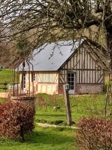ein Haus mitten auf einem grünen Feld in der Unterkunft Le gite du pré dorė in Bonneville-la-Louvet